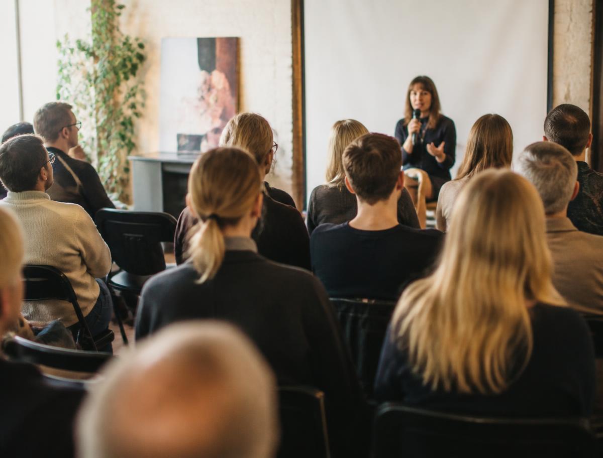 Yleisöä seminaarissa kuuntelemassa puhujaa